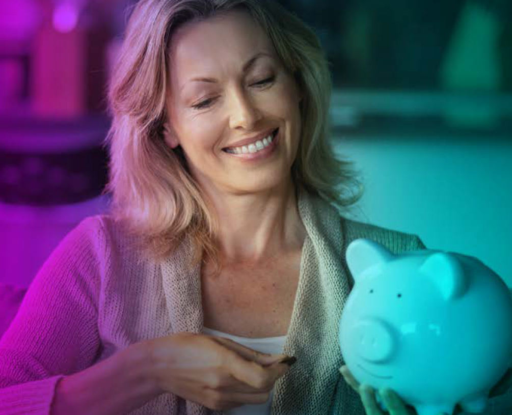 Frau lächelnd mit Sparschwein in der Hand