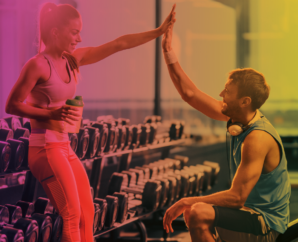 Frau und Mann im Fitnessstudio klatschen sich ab