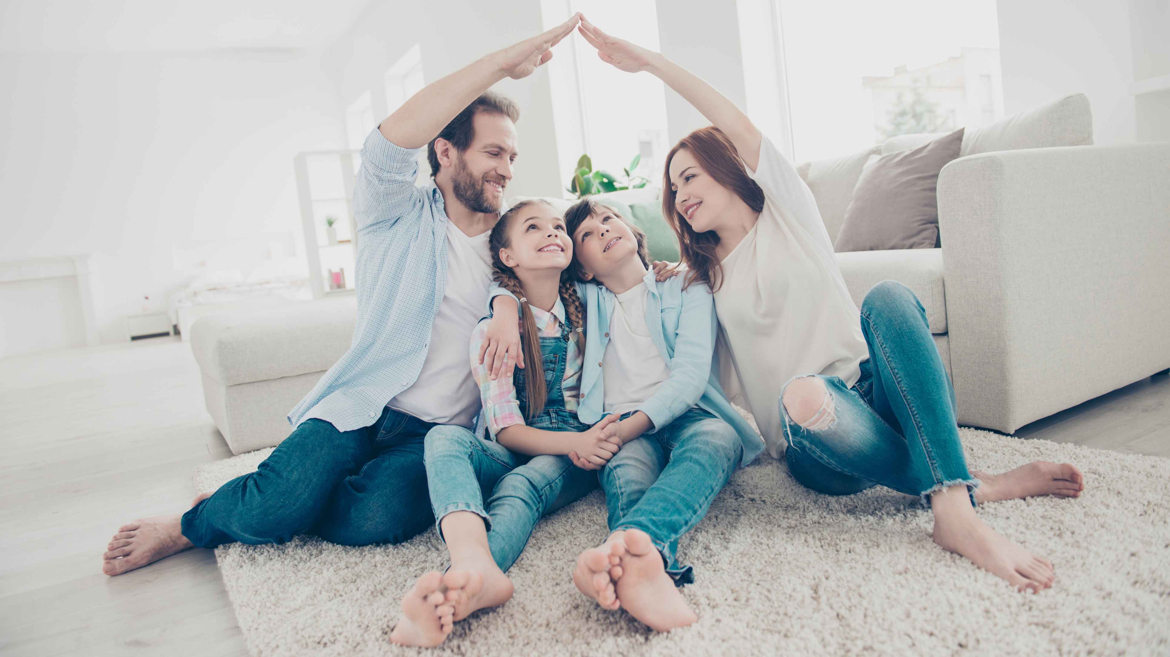Familienfoto, Vater und Mutter bilden mit der Hand einen Dach über den Köpfen der Kinder